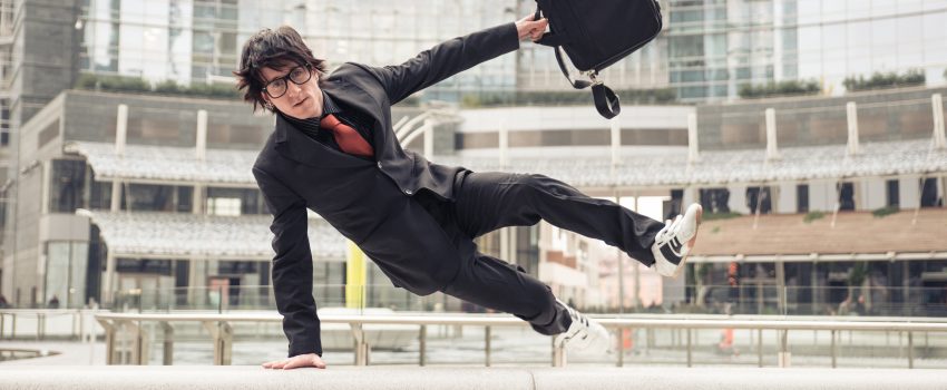 Business man with suitcase jumping over urban obstacles